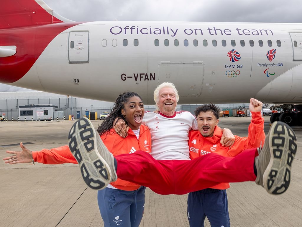 Richard Branson celebrating in front of a Virgin Atlantic Aircraft